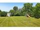 Expansive, lush backyard featuring a playset and mature trees, perfect for outdoor activities and relaxation at 7831 Bayridge Dr, Indianapolis, IN 46236
