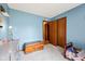 Bedroom features blue accent walls, carpet, closet, and chest for storage at 7831 Bayridge Dr, Indianapolis, IN 46236