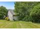 Home exterior with a well-maintained lawn, trimmed bushes, and mature trees surrounding the property at 7831 Bayridge Dr, Indianapolis, IN 46236