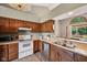 Well-lit kitchen features wood cabinets, stainless steel appliances, and a pass-through window to another room at 7831 Bayridge Dr, Indianapolis, IN 46236