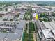 An aerial view shows a street lined with trees, as well as the surrounding area, including buildings and parking lots at 80 Monon Blvd, Carmel, IN 46032
