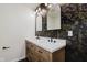 Elegant bathroom with a dual sink vanity, decorative wallpaper, and modern lighting, creating a luxurious feel at 8115 Englewood Rd, Indianapolis, IN 46240