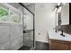 Contemporary bathroom with a glass-enclosed shower, tiled walls, and a double vanity with modern fixtures at 8115 Englewood Rd, Indianapolis, IN 46240