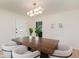 Well-lit dining room with a modern chandelier, a dark wood table, and a view of the front entry and dining table at 8115 Englewood Rd, Indianapolis, IN 46240