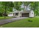 Single-story house with a brick facade and attached garage, complemented by a dark driveway and fresh green lawn at 8115 Englewood Rd, Indianapolis, IN 46240
