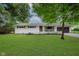 Charming single-story home featuring a brick facade, well-manicured lawn, and a two-car attached garage at 8115 Englewood Rd, Indianapolis, IN 46240