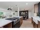 Modern kitchen with a large center island with a cooktop and stainless steel appliances, plus an adjacent breakfast nook at 8115 Englewood Rd, Indianapolis, IN 46240