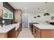 Stylish kitchen featuring a large island with white countertops, wood cabinets, herringbone backsplash, and modern pendant lighting at 8115 Englewood Rd, Indianapolis, IN 46240