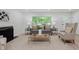 Comfortable living room features a large window, neutral decor, fireplace, and wood flooring at 8115 Englewood Rd, Indianapolis, IN 46240