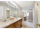 Bathroom with a double sink vanity, framed mirror, shower, and frosted sliding shower doors at 8247 Cape N Dr, Indianapolis, IN 46256