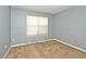 Bedroom with light gray walls, carpeted floors, a large window, and electrical outlets at 8247 Cape N Dr, Indianapolis, IN 46256