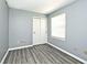 Bedroom featuring modern gray walls, laminate floors, and a window at 8247 Cape N Dr, Indianapolis, IN 46256