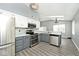 Modern kitchen design with stainless steel appliances, gray and white cabinets, and laminate flooring at 8247 Cape N Dr, Indianapolis, IN 46256