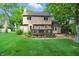 Back of the house with a well manicured lawn, wooden deck, and lots of trees at 8313 Tequista Cir, Indianapolis, IN 46236