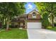 Charming two-story home with a well-manicured lawn and mature trees shading the front yard at 8313 Tequista Cir, Indianapolis, IN 46236