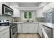 Modern kitchen with stainless steel appliances, white cabinets, and a bright window at 8313 Tequista Cir, Indianapolis, IN 46236