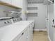 Functional laundry room with washer, dryer, utility sink, and shelving for storage at 8313 Tequista Cir, Indianapolis, IN 46236