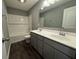 Bathroom featuring a double sink vanity, wood-look floors, and a shower-tub combo at 8969 Faulkner Dr, Indianapolis, IN 46239