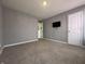 Neutral-colored bedroom featuring carpet floors, two doors, gray-painted walls, and a tv at 8969 Faulkner Dr, Indianapolis, IN 46239