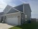 Side view of a two-story home highlighting its blue siding, brick accents, and attached garage at 8969 Faulkner Dr, Indianapolis, IN 46239
