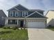 Charming two-story home featuring a brick facade, blue siding, and a well-maintained front lawn at 8969 Faulkner Dr, Indianapolis, IN 46239