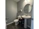 Cozy half bathroom with modern fixtures, a pedestal sink, and a decorative mirror at 8969 Faulkner Dr, Indianapolis, IN 46239