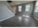 Inviting living room featuring hardwood floors and a staircase, illuminated by natural light at 8969 Faulkner Dr, Indianapolis, IN 46239