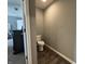 A view of the powder room showing the toilet and the hardwood style flooring at 8969 Faulkner Dr, Indianapolis, IN 46239