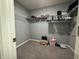 Walk-in closet features built-in shelves for optimal storage, carpeted flooring, and gray walls at 8969 Faulkner Dr, Indianapolis, IN 46239