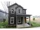 Charming two-story home showcasing gray siding, a covered porch, and a vibrant yellow front door at 9516 Bauhaus Way, Indianapolis, IN 46240