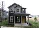 Inviting two-story house with stylish gray siding, a covered porch, and a cheerful yellow front door at 9516 Bauhaus Way, Indianapolis, IN 46240