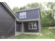 Modern two-story home with a dark gray exterior, back patio, and well-maintained lawn at 9516 Bauhaus Way, Indianapolis, IN 46240