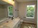 Modern bathroom featuring double sinks, a large mirror, and natural lighting at 9520 Bauhaus Way, Indianapolis, IN 46240