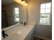 Bright bathroom features a large double sink vanity, large mirror, and natural light from two windows at 9520 Bauhaus Way, Indianapolis, IN 46240