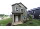 Charming two-story home with a covered porch, green siding, and a well-manicured lawn at 9520 Bauhaus Way, Indianapolis, IN 46240