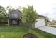 Exterior view of a two-story home with green siding, white garage door, and landscaping at 9520 Bauhaus Way, Indianapolis, IN 46240