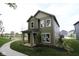 Stunning view of a two-story home with green siding, a well-kept lawn, and a sidewalk at 9520 Bauhaus Way, Indianapolis, IN 46240