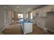 A modern kitchen featuring white cabinets, a kitchen island, and an open layout into the living space at 9520 Bauhaus Way, Indianapolis, IN 46240