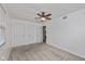 Spacious bedroom with neutral carpet, ceiling fan, window, and three closets for ample storage at 10016 Penrith Dr, Indianapolis, IN 46229