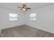 Bright bedroom featuring neutral carpet, two windows, and ceiling fan at 10016 Penrith Dr, Indianapolis, IN 46229