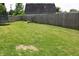 Large grassy backyard with a wooden fence, providing a secure and private outdoor space at 103 Bentwood Dr, Greenwood, IN 46143