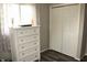 Bright bedroom featuring a white dresser, white closet doors, and neutral colored walls and curtains at 103 Bentwood Dr, Greenwood, IN 46143