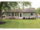 Charming single-story home featuring green siding, a manicured lawn, and lovely landscaping at 103 Bentwood Dr, Greenwood, IN 46143