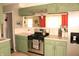 Updated kitchen with green cabinets, stainless steel appliances, and ample counter space at 103 Bentwood Dr, Greenwood, IN 46143