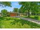 Ranch-style home with a long driveway and a well-manicured lawn, situated on a tree-filled lot at 108 Bennett Rd, Carmel, IN 46032