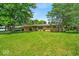 Single-story home with a large front lawn and mature trees providing shade at 108 Bennett Rd, Carmel, IN 46032