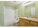 Bright bathroom featuring a shower-tub combo, a single sink and light green walls at 1138 Topp Creek Dr, Indianapolis, IN 46214