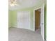 Bedroom with green-painted walls, carpet, and a view into an adjoining room at 1138 Topp Creek Dr, Indianapolis, IN 46214