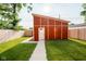 Backyard featuring a modern shed with unique architecture, manicured lawn, and fenced yard at 1210 Churchman Ave, Indianapolis, IN 46203