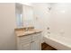 Well-lit bathroom features a granite vanity, undermount sink, tub, and white cabinets at 1210 Churchman Ave, Indianapolis, IN 46203